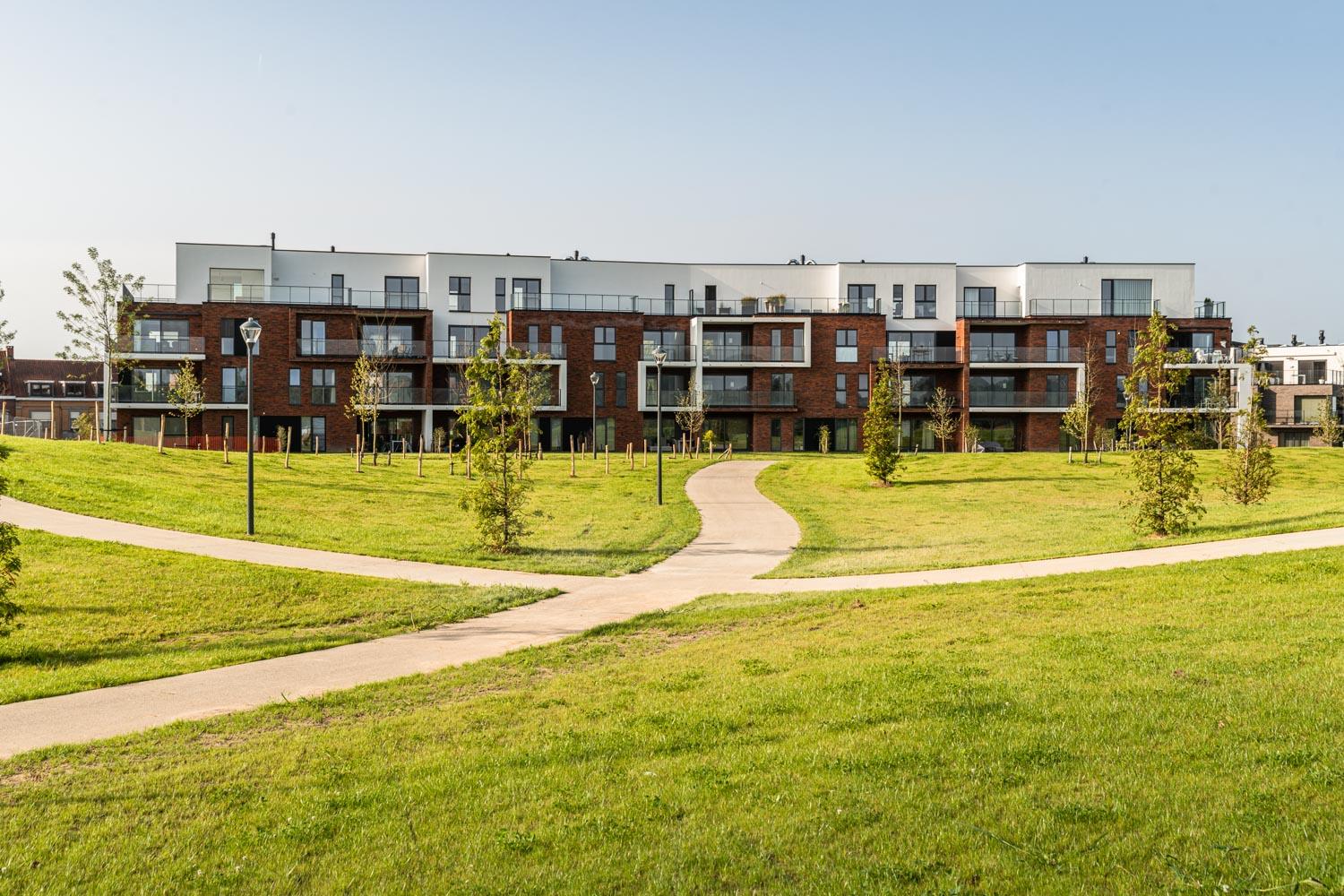Parktuin en voorgevel appartementsgebouwen De Stadstuin op achtergrond